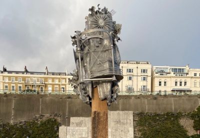 Beachcomber sculptures by Anna Dumitriu and Alex May. An abstract metal sculpture mounted on a wooden pole on Brighton seafront.